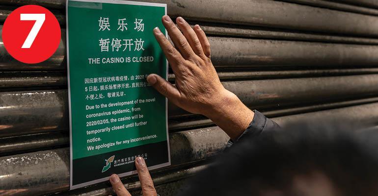 An employee puts up a closing notice on the gate of the main entrance of Casino Lisboa after its closing 