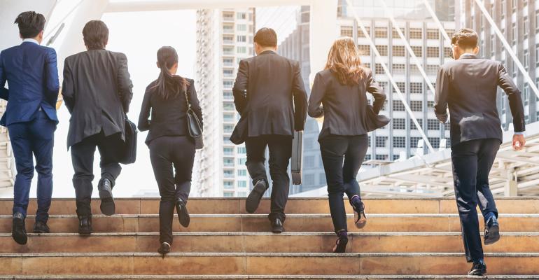 group of young businessmen and women running up stairs pro bono work